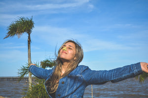 Blonde women by the beach wearing yellow Noz sunscreen on her nose